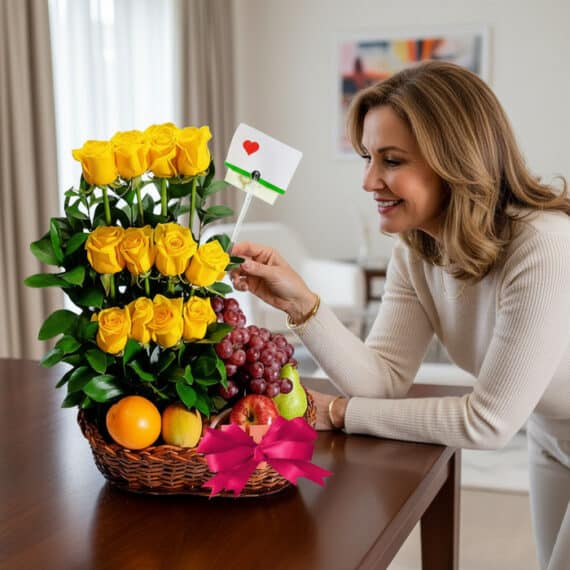 Mujer elegante admirando un Arreglo Floral con Frutas Paraíso, compuesto por rosas amarillas, uvas, manzanas y naranjas en un