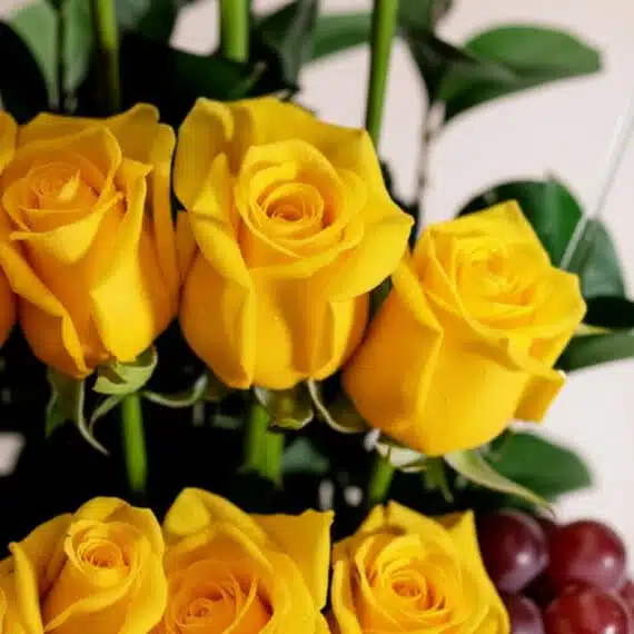 Primer plano extremo de rosas amarillas frescas con gotas de rocío, parte del Arreglo Floral Paraíso, mostrando textura hiper