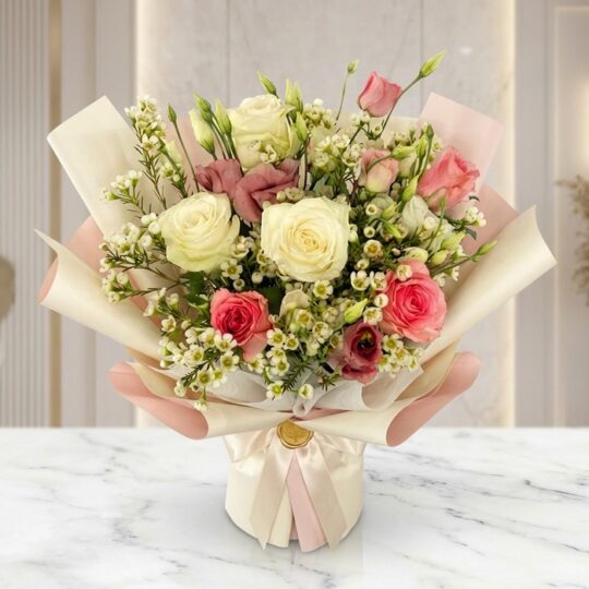 Bouquet Floral SUSANA con rosas blancas y rosadas, astromelias y follaje verde, envuelto en papel coreano rosa y crema, sobre