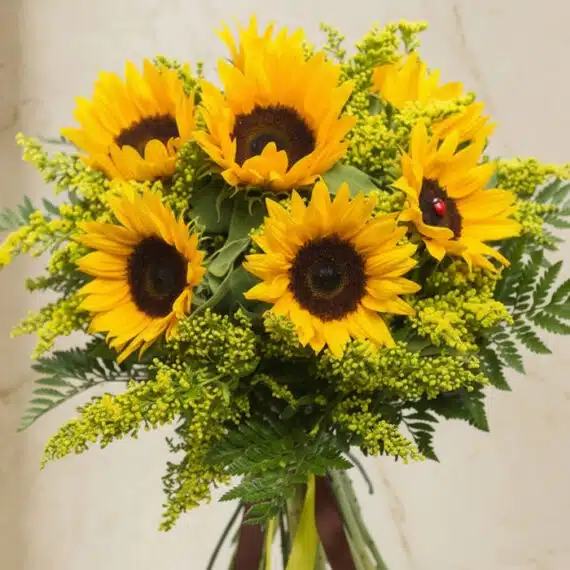 Primer plano extremo de un bouquet de girasoles LAIA con 10 flores, mostrando texturas hiperrealistas, gotas de rocío y color