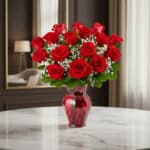 Jarrón Amor Incondicional con un hermoso arreglo de rosas rojas frescas y follaje verde, sobre una mesa de mármol en un elega